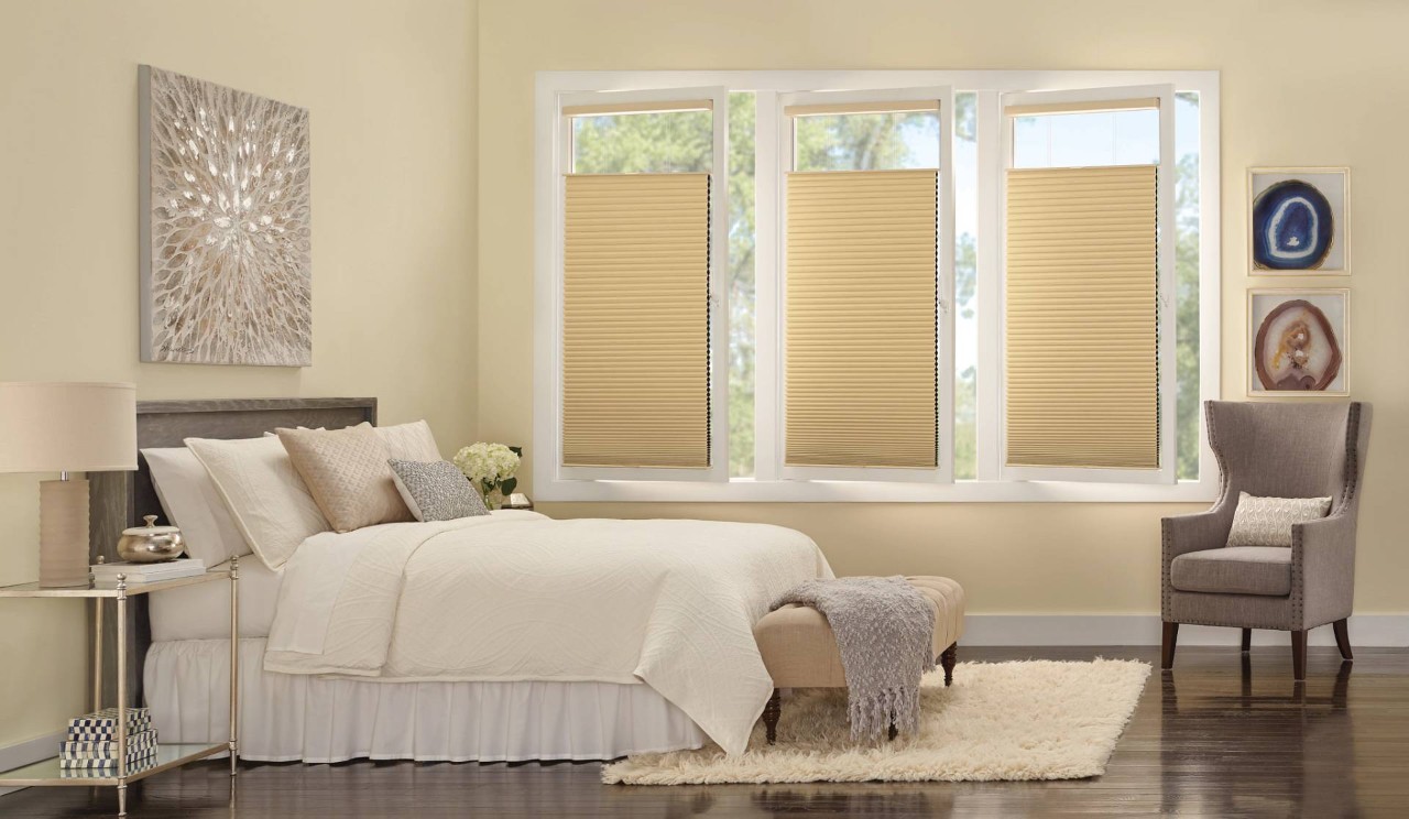 Three sets of Tan Hunter Douglas Duette® Cellular Shades decorating a bedroom’s windows near Dallas, TX